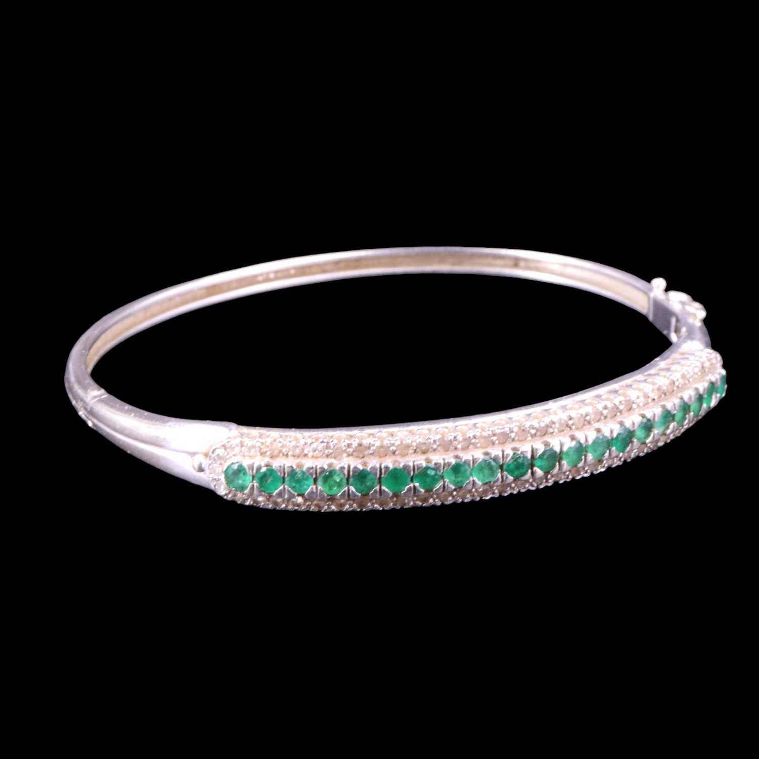 Lot 1517 - An emerald and diamond hinged bangle,...