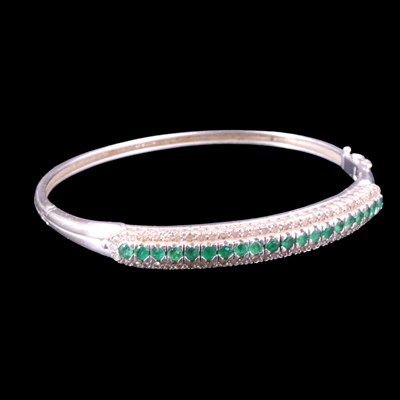 Lot 1517 - An emerald and diamond hinged bangle,...