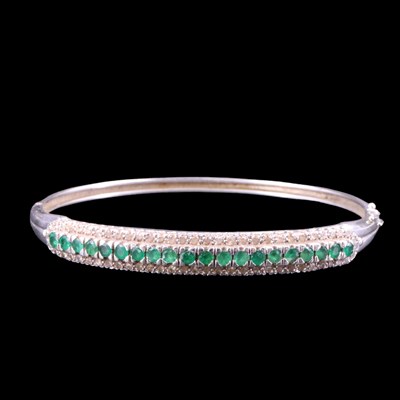 Lot 1517 - An emerald and diamond hinged bangle,...