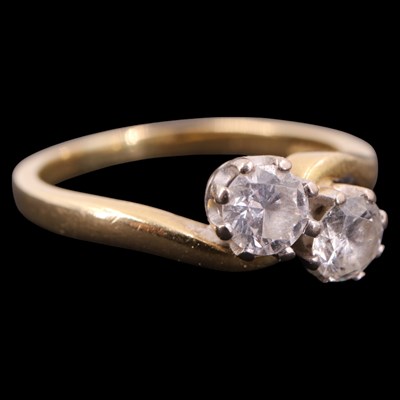 Lot 1394 - A two-stone diamond crossover ring, comprising...