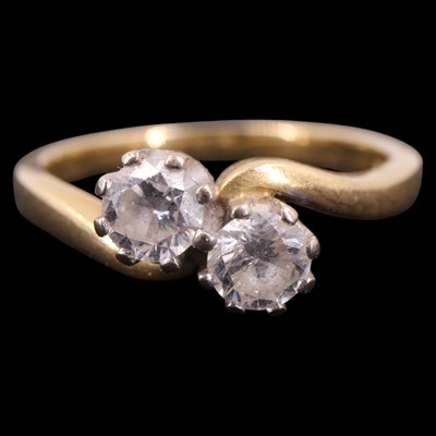 Lot 1394 - A two-stone diamond crossover ring, comprising...