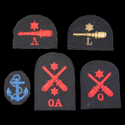 Lot 222 - Four Royal Navy gunner trade badges together...