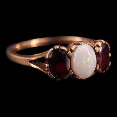 Lot 1360 - A mid 1970s opal and garnet three-stone...