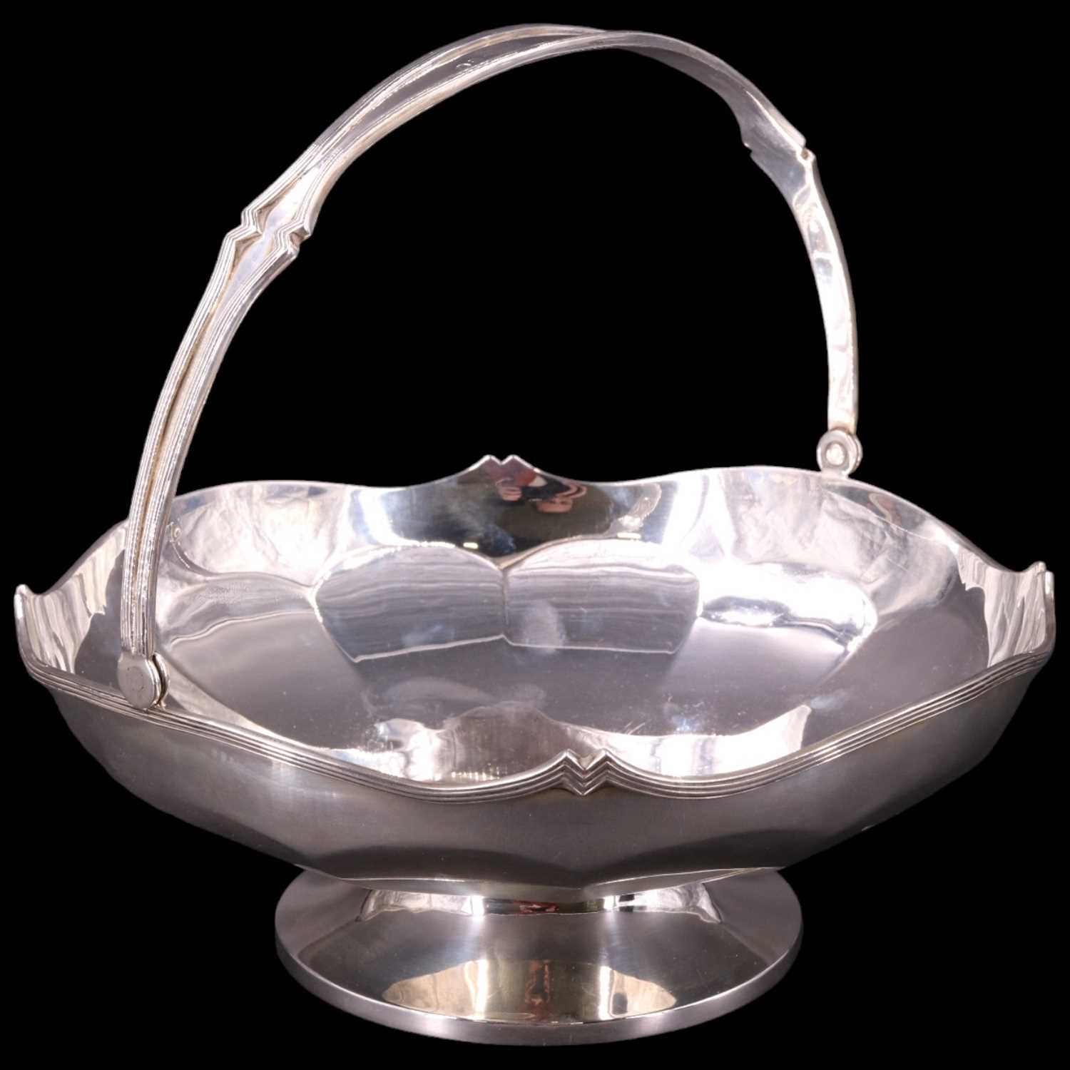 Lot 891 - A 1920s silver large swing-handled footed bowl,...
