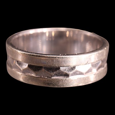 Lot 1027 - A contemporary 9 ct white gold facetted band,...