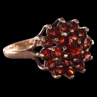 Lot 1020 - A 1970s garnet cluster ring, comprising a...