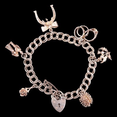 Lot 1031 - A 1970s silver charm bracelet, having Scottish...