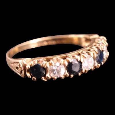 Lot 1040 - A 1990s sapphire and white gemstone half-hoop...