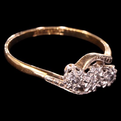 Lot 1350 - A vintage three-stone diamond crossover ring,...