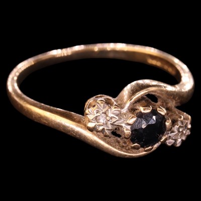 Lot 1351 - A 1990s three-stone sapphire and diamond ring,...