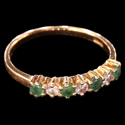 Lot 1366 - A 1980s emerald and diamond half hoop eternity...