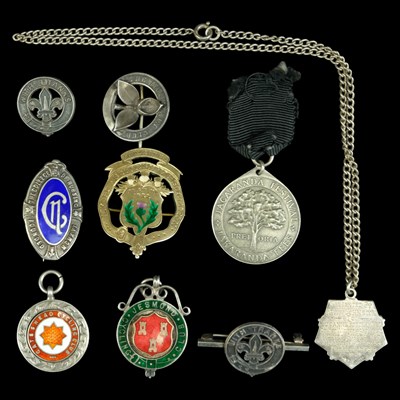 Lot 559 - A group of silver badges, medals and fobs,...
