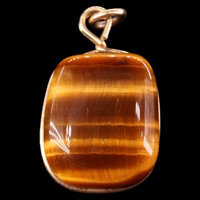 Lot 1489 - A tiger's eye and 9 ct gold pendant, 23 mm x...