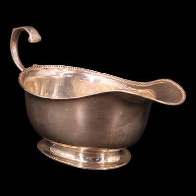 Lot 1196 - A George V silver sauce boat, having an...