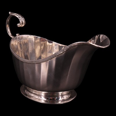 Lot 1200 - A 1930s silver faceted sauce boat, having an...