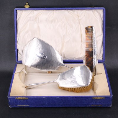 Lot 1171 - A cased Art Deco silver three-piece dressing...