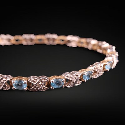 Lot 1275 - A contemporary blue topaz and diamond tennis...