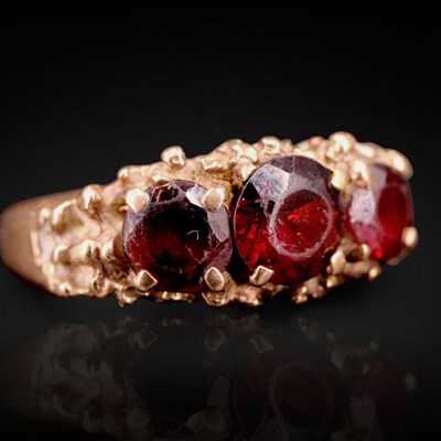 Lot 1283 - A 1970s three-stone garnet ring, comprising...