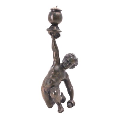 Lot 1376 - A bronzed brass figural candlestick in the...