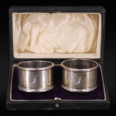 Lot 1110 - A 1930s cased pair of silver napkin...