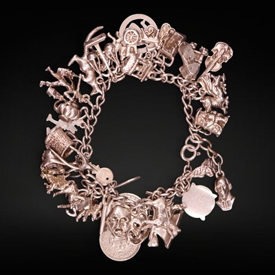 Lot 1219A - A vintage white metal charm bracelet, having...